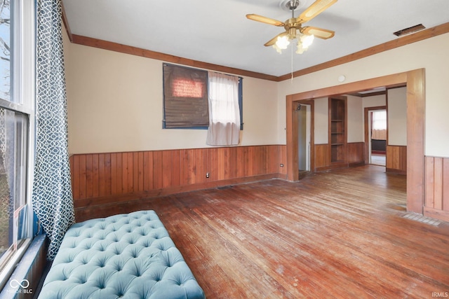 interior space featuring hardwood / wood-style floors, plenty of natural light, wooden walls, and ceiling fan