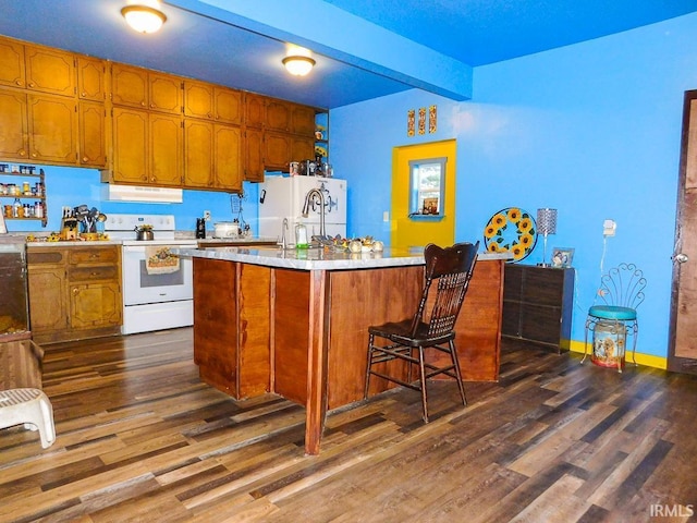 kitchen featuring white appliances, a kitchen breakfast bar, beamed ceiling, a kitchen island, and dark hardwood / wood-style flooring