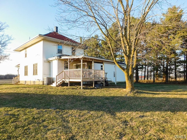 rear view of house with central AC, a yard, and a deck