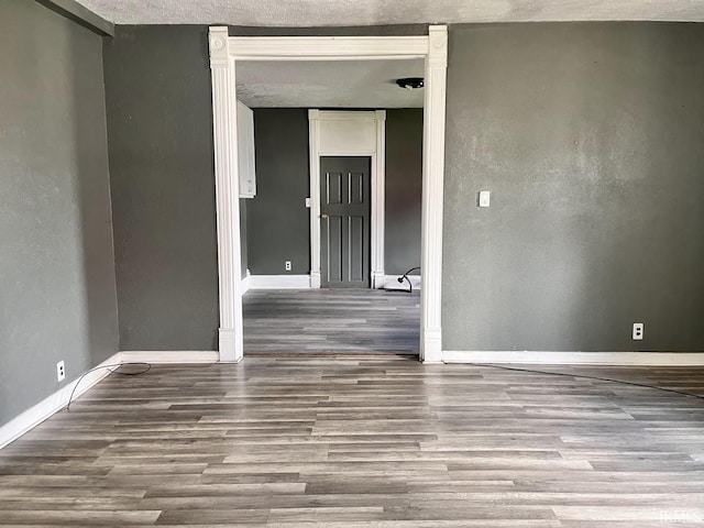 empty room with hardwood / wood-style floors and a textured ceiling