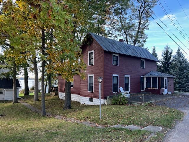 view of front of property featuring a front lawn and a sunroom