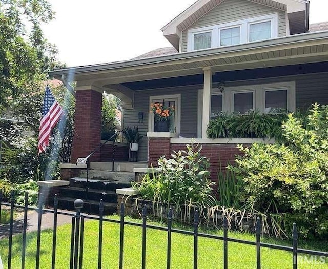 view of front of property with a front yard and covered porch