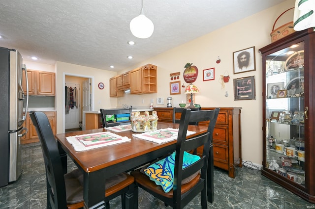 dining space featuring sink and a textured ceiling