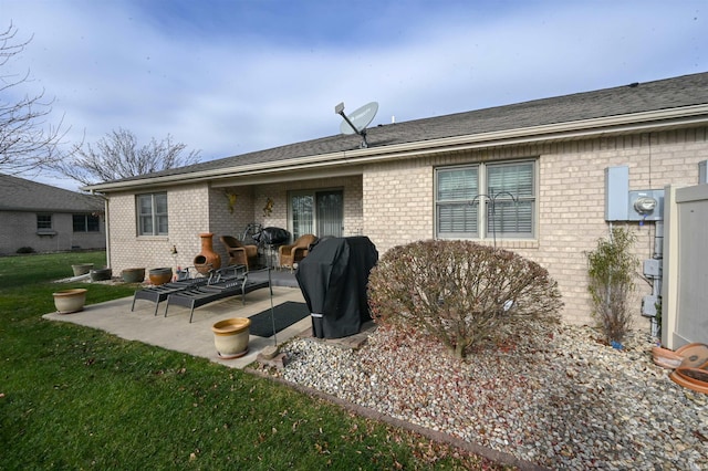 rear view of property with a patio area and a lawn