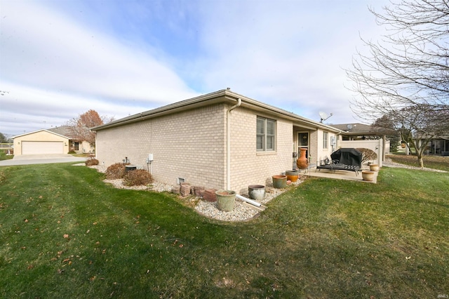 view of side of property with a patio and a lawn