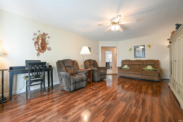 living room featuring dark hardwood / wood-style floors, ceiling fan, and a textured ceiling