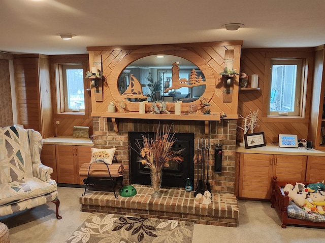 carpeted living room with wooden walls and a fireplace