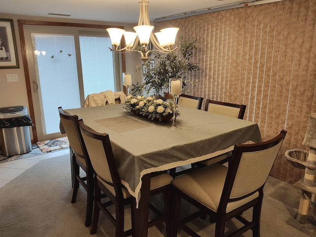 dining space with tile patterned flooring and a chandelier