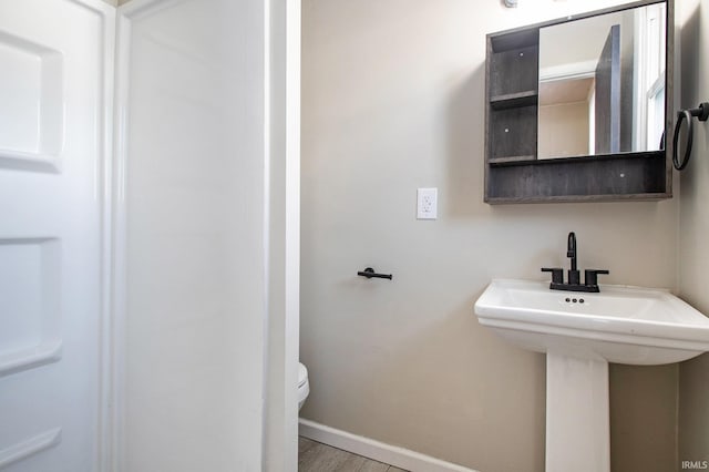 bathroom with hardwood / wood-style flooring, toilet, and sink