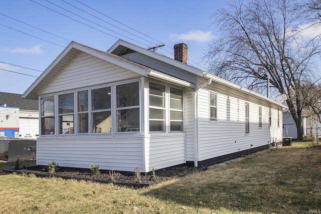 view of property exterior featuring a sunroom and a yard