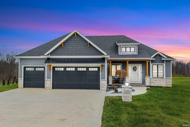 craftsman-style home featuring a yard and a garage