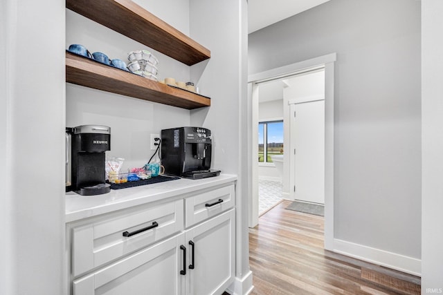 bar featuring white cabinets and light hardwood / wood-style floors