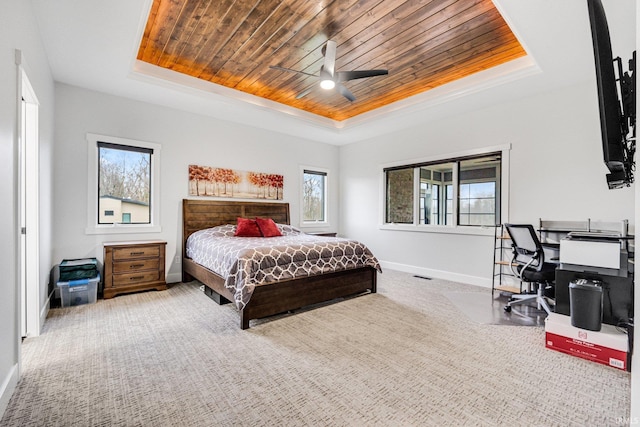 carpeted bedroom with ceiling fan, a raised ceiling, and wooden ceiling