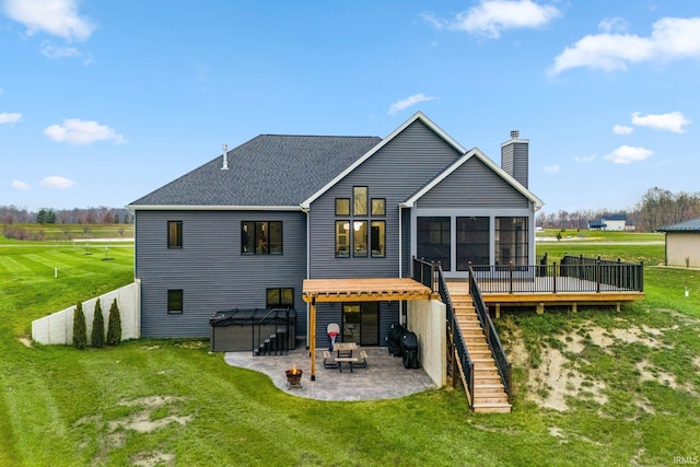 rear view of property featuring a yard, a hot tub, a deck, and a patio area