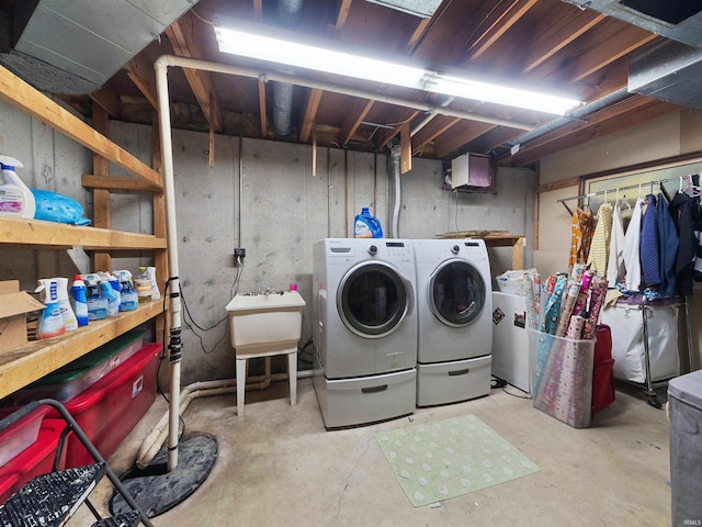 clothes washing area with washer and clothes dryer and sink