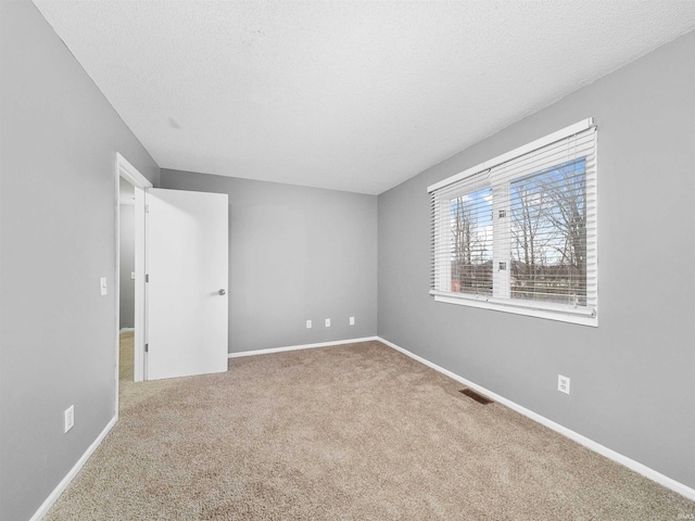 carpeted spare room with a textured ceiling