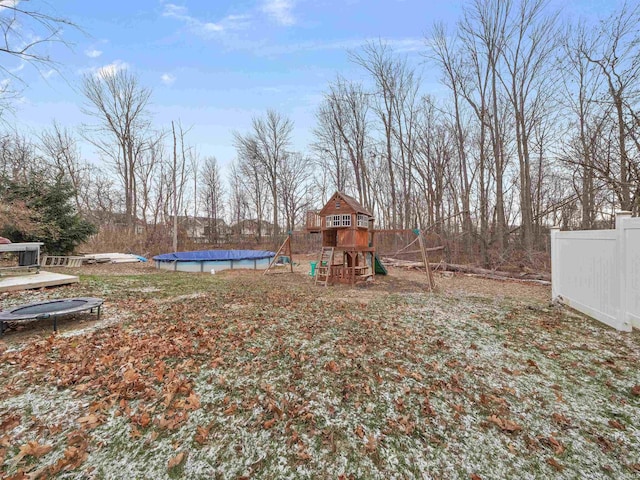 view of yard featuring a playground, a trampoline, and a covered pool