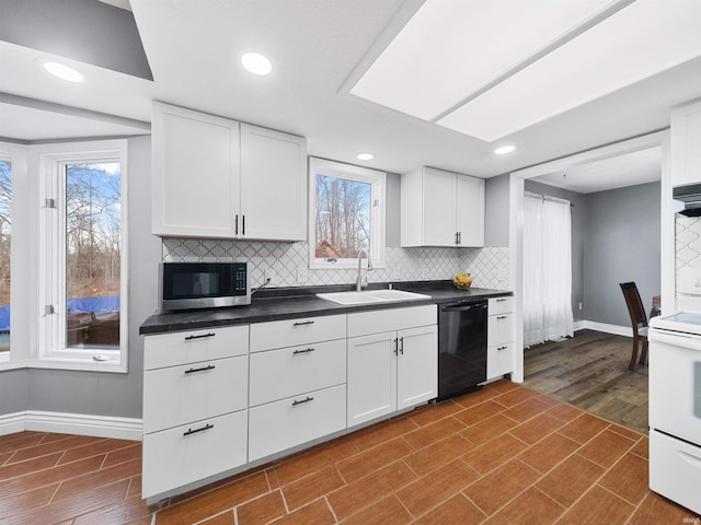 kitchen featuring sink, black dishwasher, tasteful backsplash, white cabinets, and hardwood / wood-style flooring