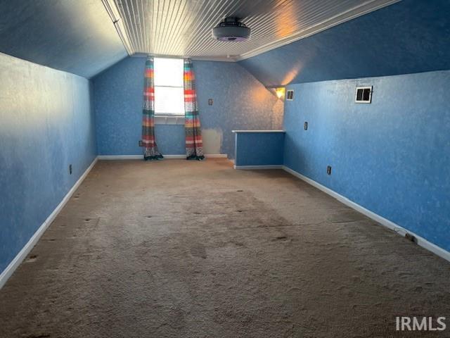 bonus room with carpet floors and vaulted ceiling