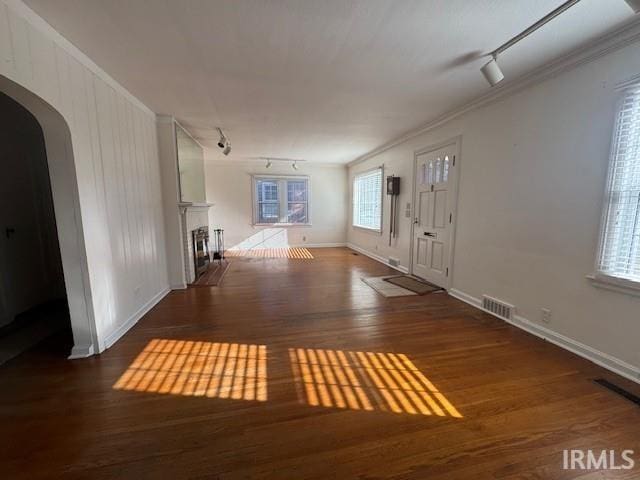 foyer entrance featuring dark wood-type flooring, track lighting, and ornamental molding