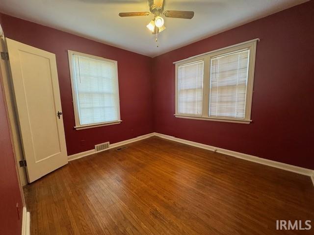 spare room featuring ceiling fan, plenty of natural light, and hardwood / wood-style flooring