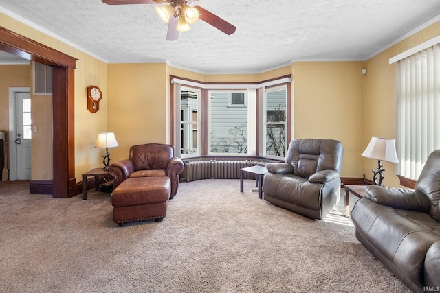 carpeted living room with ceiling fan, crown molding, and a textured ceiling