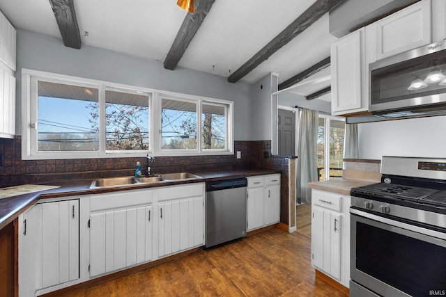 kitchen featuring beamed ceiling, decorative backsplash, and appliances with stainless steel finishes