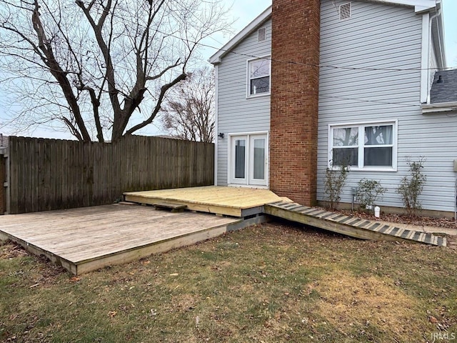 back of house with a deck and a yard