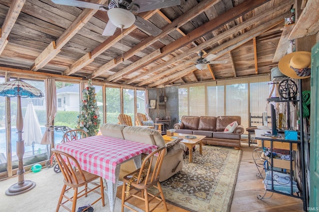 sunroom / solarium with lofted ceiling with beams, ceiling fan, and wood ceiling