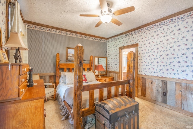 bedroom with a textured ceiling, ceiling fan, light carpet, and wood walls