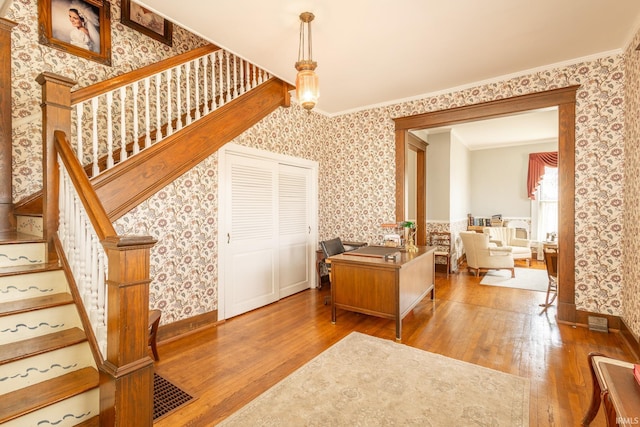 entryway featuring ornamental molding and light wood-type flooring