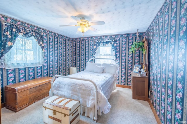 carpeted bedroom featuring ceiling fan and a textured ceiling