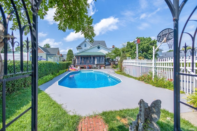 view of pool with a sunroom and a patio area