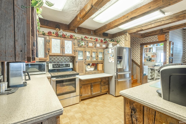 kitchen with beamed ceiling, appliances with stainless steel finishes, and light parquet floors