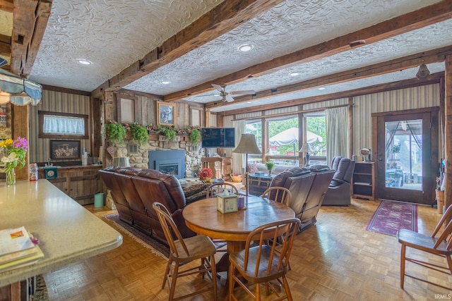 dining space featuring beam ceiling, ceiling fan, light parquet floors, and a textured ceiling