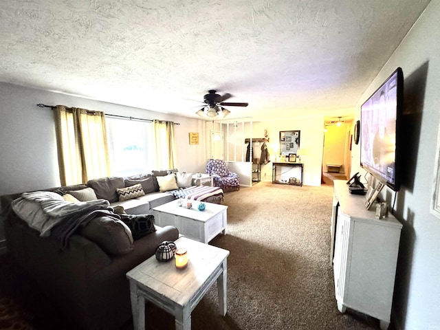 carpeted living room featuring ceiling fan and a textured ceiling