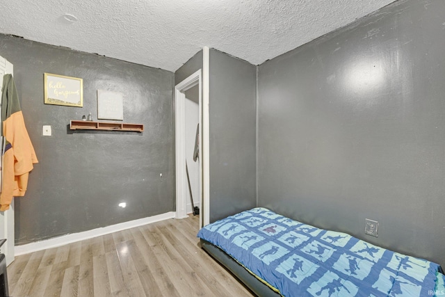 bedroom featuring light hardwood / wood-style floors and a textured ceiling