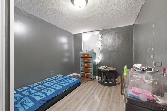 bedroom featuring hardwood / wood-style floors and a textured ceiling