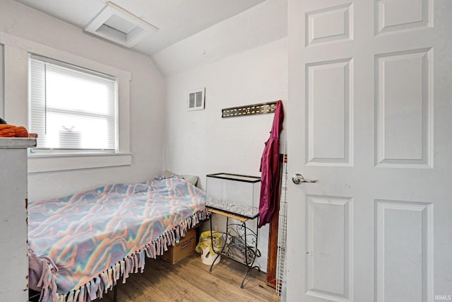 bedroom featuring lofted ceiling and hardwood / wood-style flooring