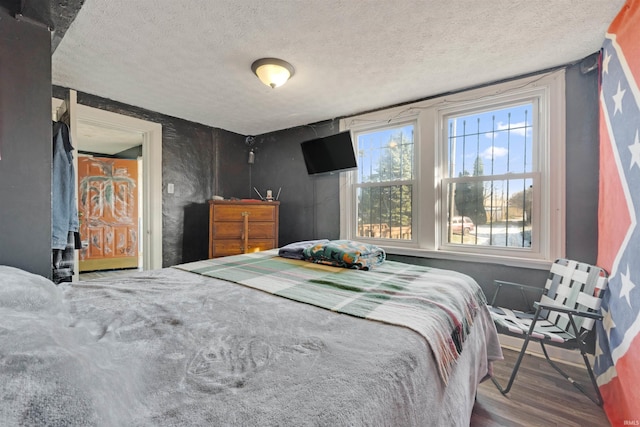 bedroom with wood-type flooring and a textured ceiling