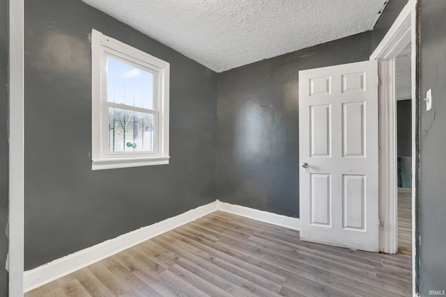 unfurnished bedroom featuring a textured ceiling and light hardwood / wood-style flooring