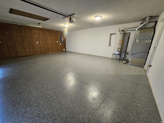 garage featuring electric panel, wooden walls, a garage door opener, and gas water heater