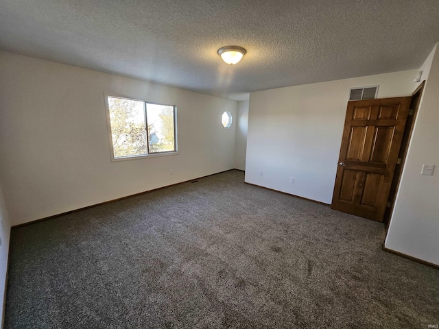 carpeted empty room with a textured ceiling