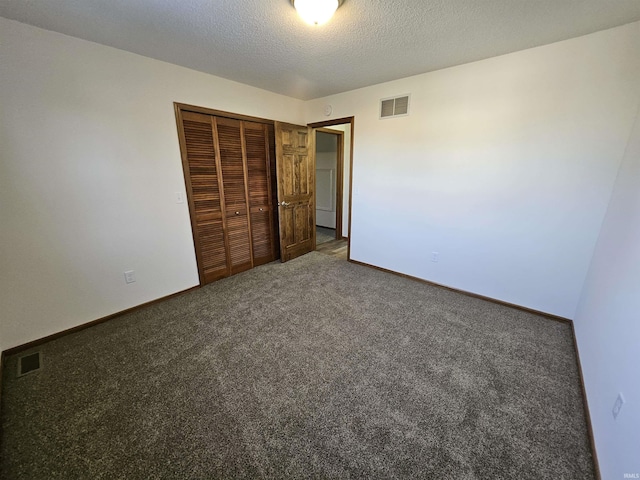 unfurnished bedroom featuring carpet flooring, a textured ceiling, and a closet