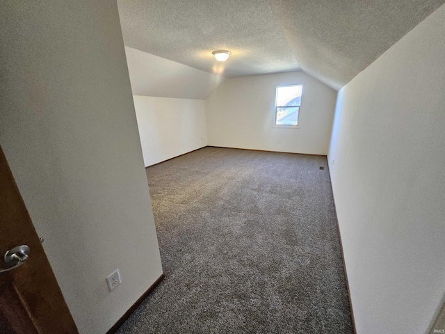 bonus room featuring dark colored carpet, a textured ceiling, and vaulted ceiling