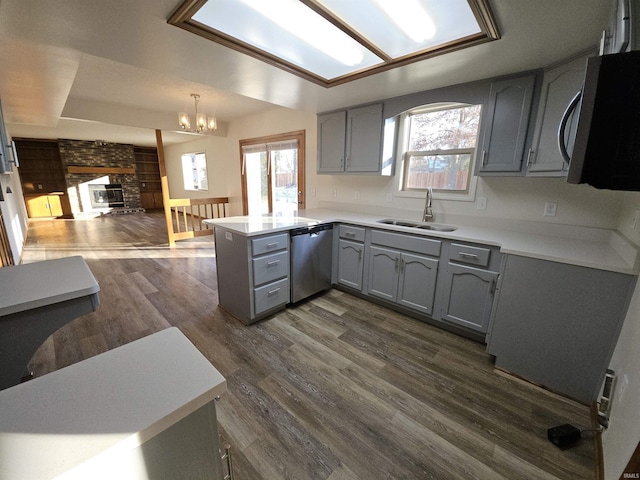 kitchen with kitchen peninsula, dark hardwood / wood-style flooring, stainless steel appliances, and sink