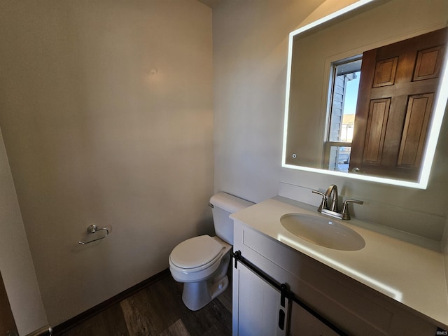 bathroom featuring vanity, hardwood / wood-style flooring, and toilet