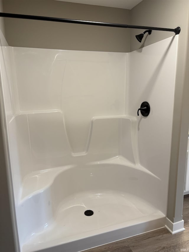 full bathroom with wood finished floors and walk in shower