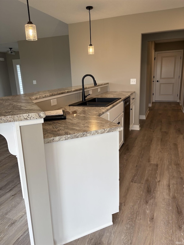kitchen with white cabinets, pendant lighting, wood finished floors, and a sink
