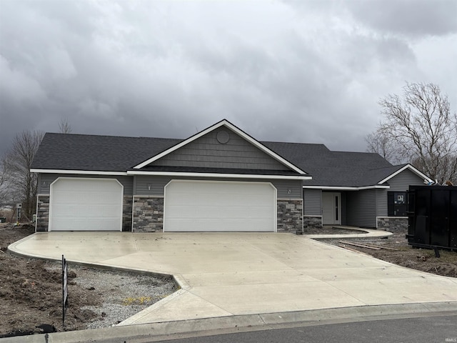 ranch-style house with a garage, stone siding, a shingled roof, and concrete driveway